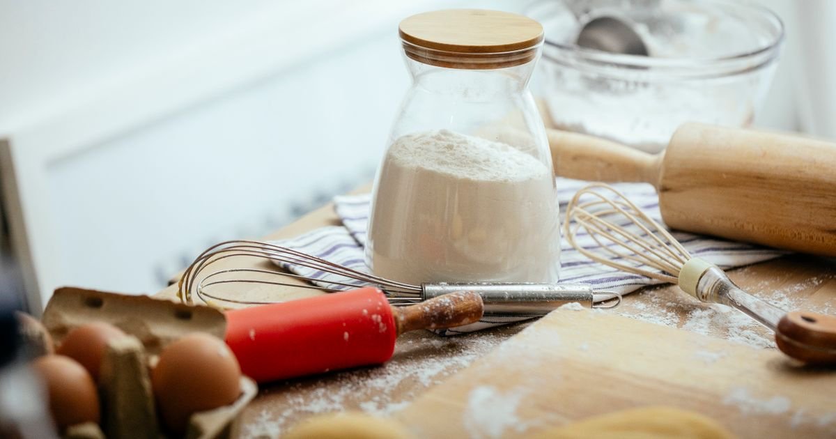 A pink shield with a cupcake inside, on a cream background — Price It Right's guide to food business insurance for UK home bakers